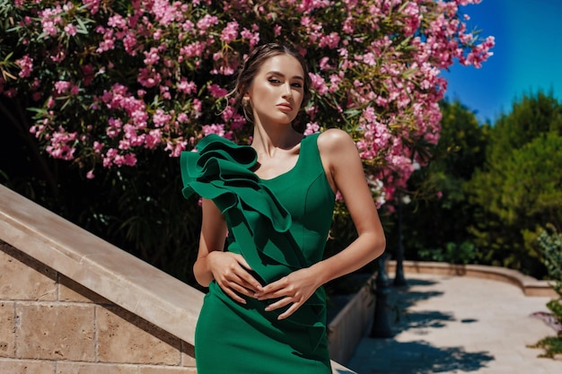 Fille dans une belle robe élégante verte dans le parc