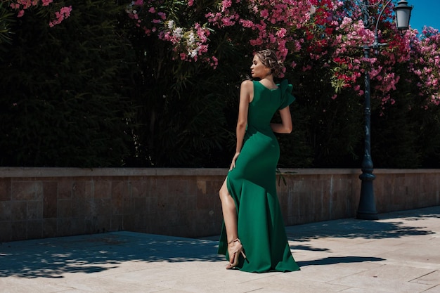 Fille dans une belle robe élégante verte dans le parc