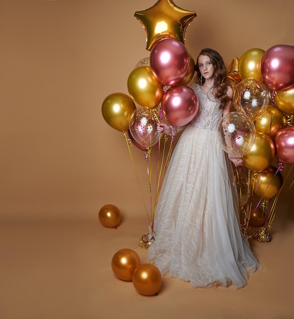 Une fille dans une belle robe tient des ballons, un endroit pour copier