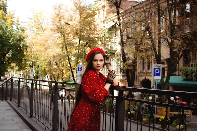 Une fille dans un béret rouge se promène dans la ville d'automne