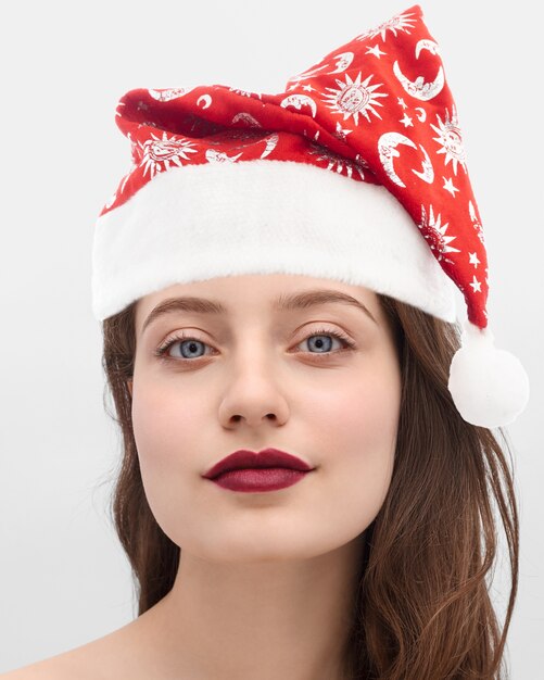 Fille dans un bonnet de Noel sur fond gris.