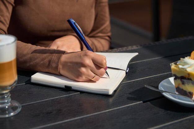 Photo une fille dans un café écrit dans un cahier