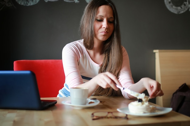 Fille dans un café pour une tasse de café avec le cahier