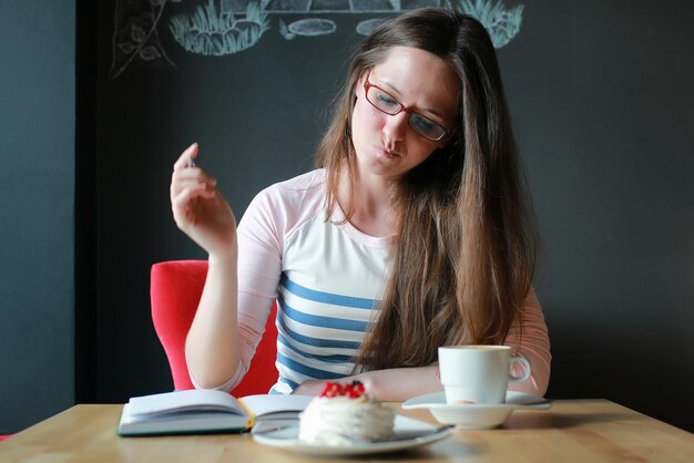 Fille dans un café pour une tasse de café avec le cahier