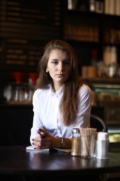 La fille dans le café prend son petit déjeuner à paris