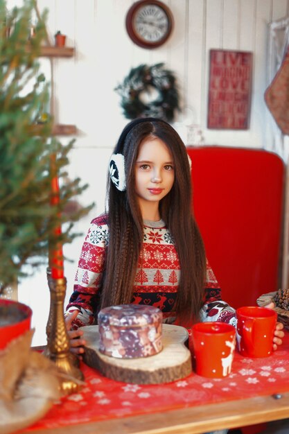 Fille dans une chambre avec arbre de Noël et décorations