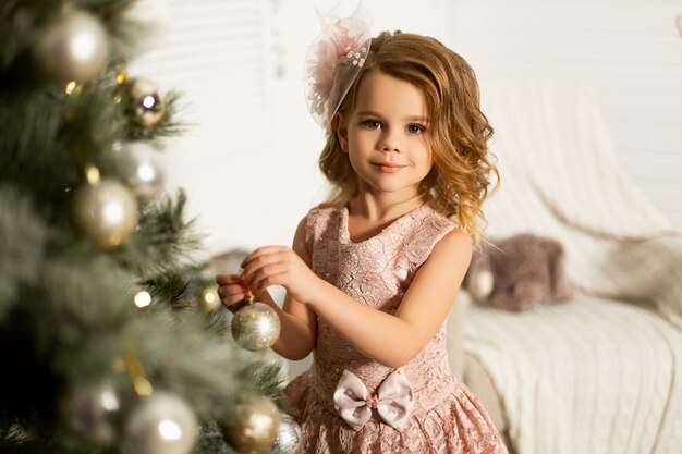 Fille dans une chambre avec arbre de Noël et décorations