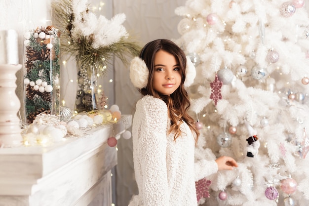 Fille dans une chambre avec des décorations de Noël