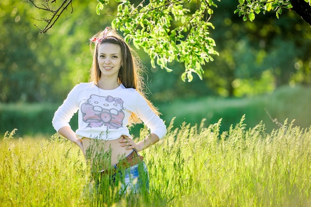 une fille dans un champ avec une chemise qui dit hello kitty sur elle