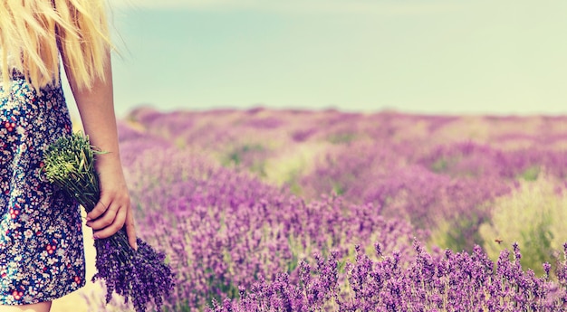 Fille dans un champ fleuri de lavande.