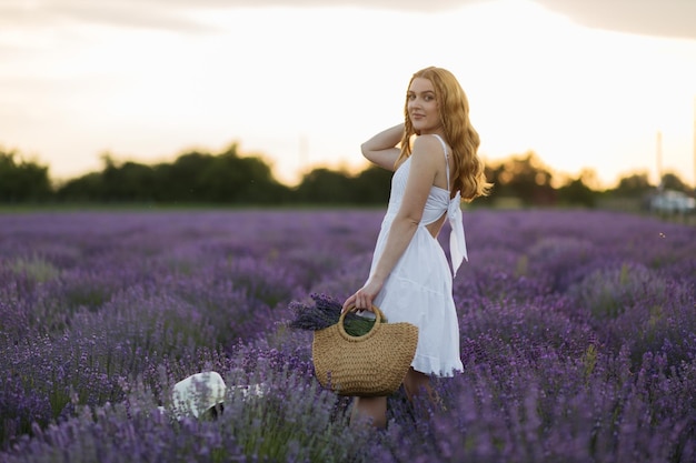 Fille dans un champ de lavande Femme dans un champ de fleurs de lavande au coucher du soleil dans une robe blanche France Provence