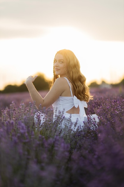 Fille dans un champ de lavande Femme dans un champ de fleurs de lavande au coucher du soleil dans une robe blanche France Provence