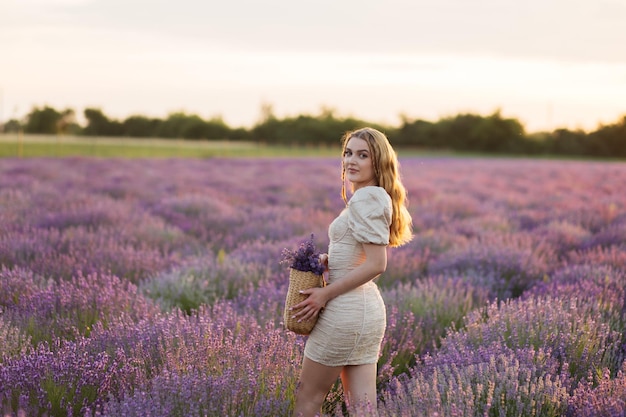 Fille dans un champ de lavande Femme dans un champ de fleurs de lavande au coucher du soleil dans une robe blanche France Provence