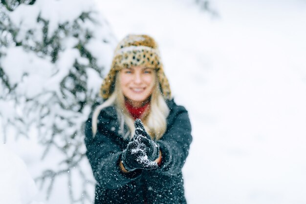 Photo fille dans un chapeau d'hiver à la mode avec un imprimé léopard se réjouit de la neige