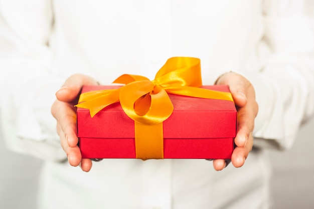 fille dans une chemise blanche détient un cadeau.