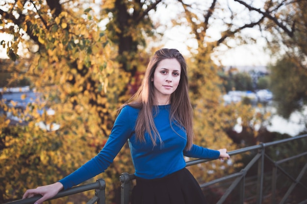 Fille dans une chemise à manches longues bleue et une jupe dans une rue. Temps de l&#39;automne.