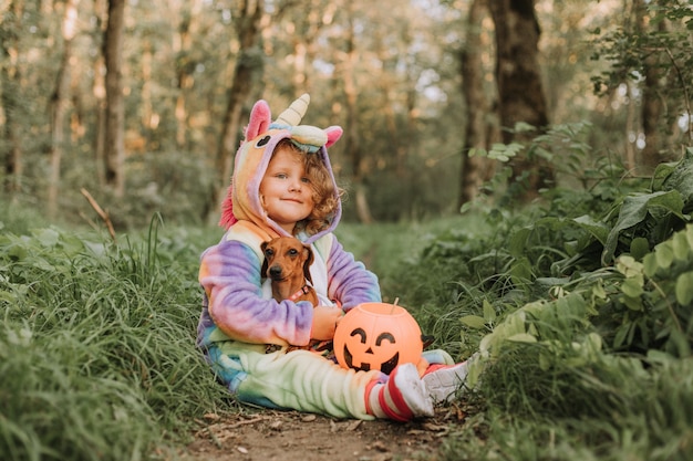 fille dans un costume de kigurumi de licorne arc-en-ciel un chien dans une robe avec une jupe pleine d'espace pour le texte