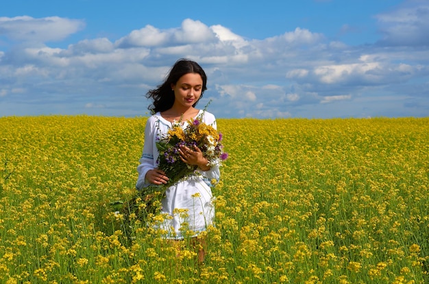 Une fille dans le costume national de l'Ukraine dans un champ de fleurs