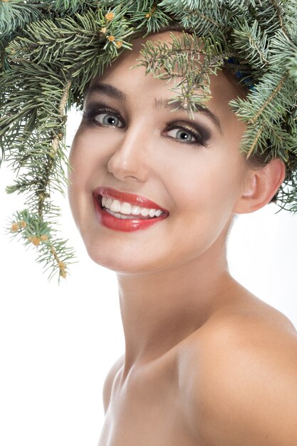 La fille dans une couronne de branches de sapin