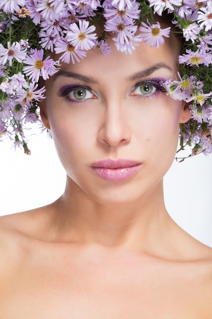 La fille dans une couronne de marguerites violettes