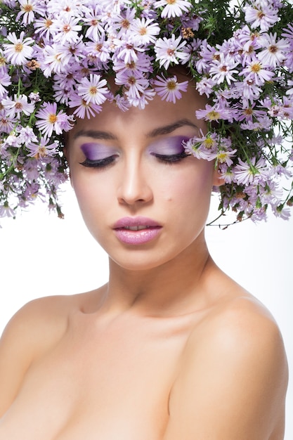 La fille dans une couronne de marguerites violettes