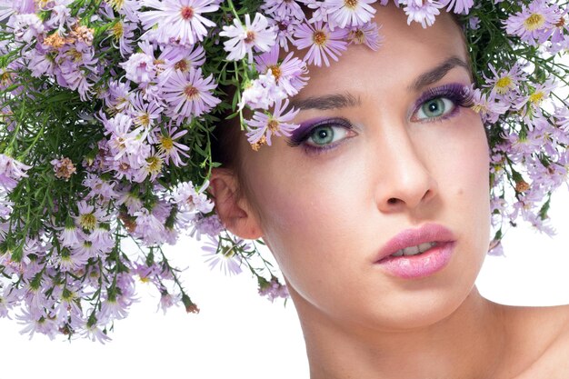 La fille dans une couronne de marguerites violettes