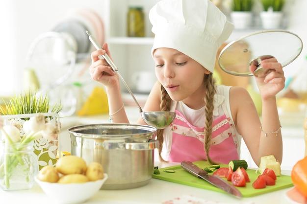 Fille dans la cuisine cuisinier à manger