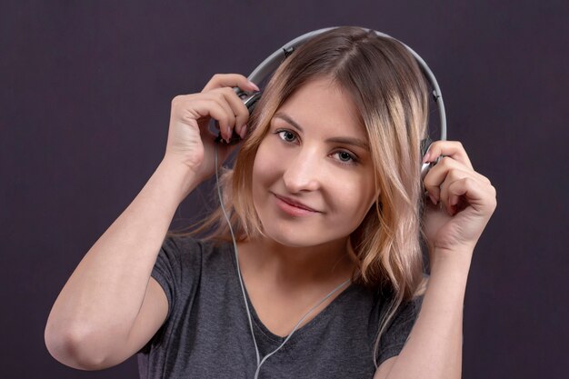 Fille dans les écouteurs, écouter de la musique et profiter de sourire