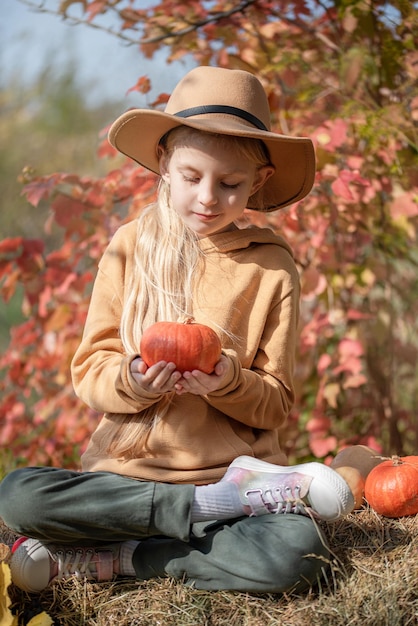 Fille dans le foin avec des citrouilles