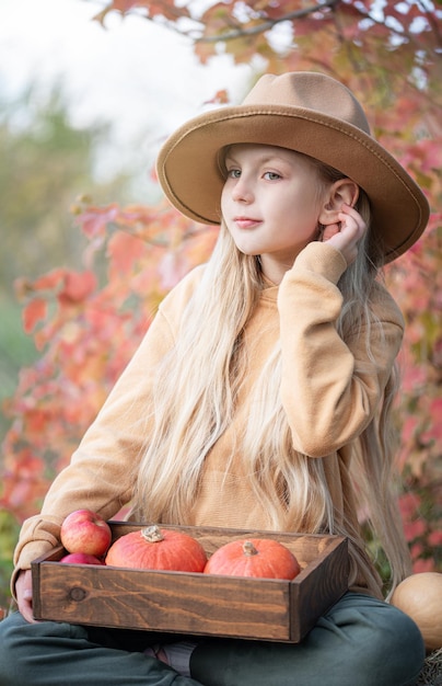 Fille dans le foin avec des citrouilles