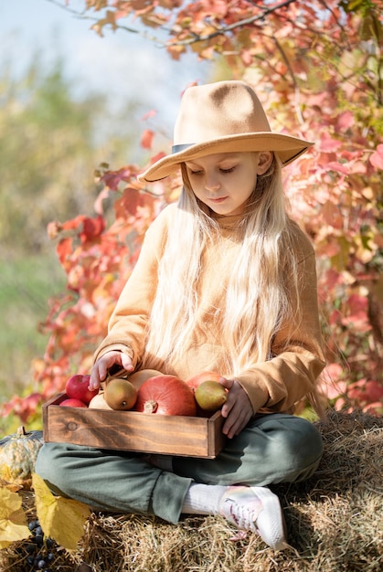 Fille dans le foin avec des citrouilles