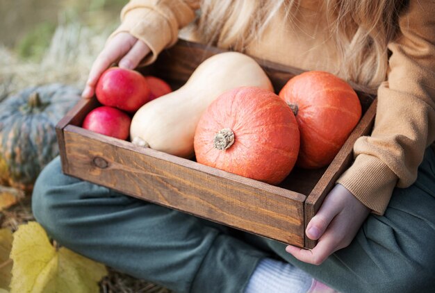 Fille dans le foin avec des citrouilles