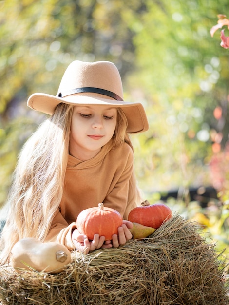 Fille dans le foin avec des citrouilles