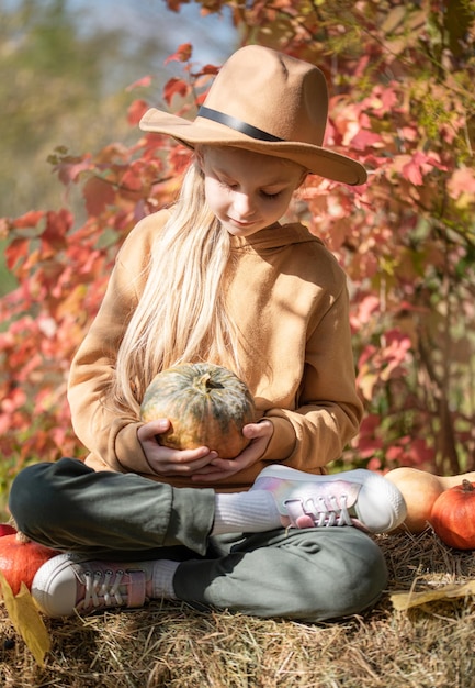 Fille dans le foin avec des citrouilles