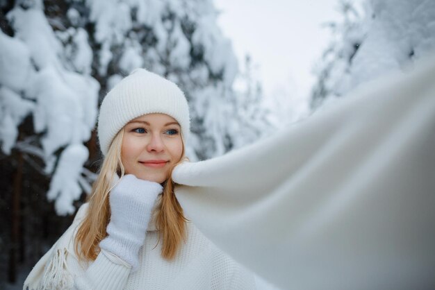 Une fille dans une forêt d'hiver, blonde, une promenade amusante dans la nature