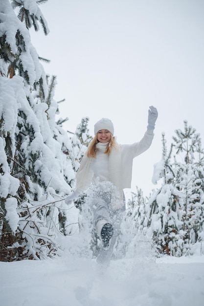 Une fille dans une forêt d'hiver, blonde, une promenade amusante dans la nature