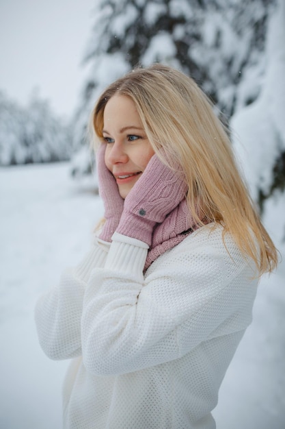 Une fille dans une forêt d'hiver, blonde, une promenade amusante dans la nature