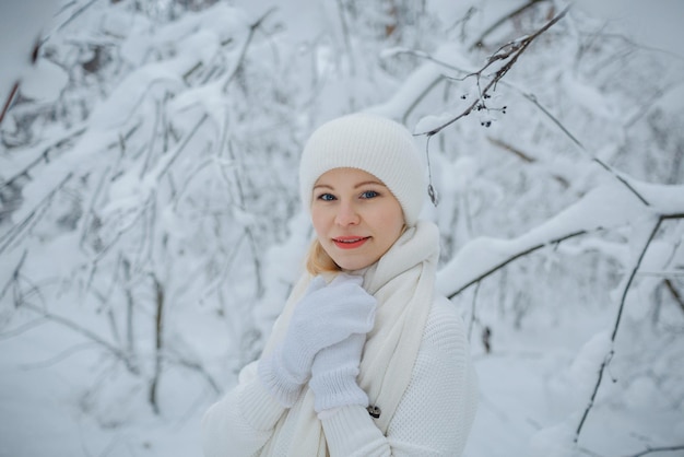 Une fille dans une forêt d'hiver, blonde, une promenade amusante dans la nature