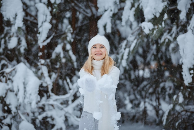 Une fille dans une forêt d'hiver, blonde, une promenade amusante dans la nature