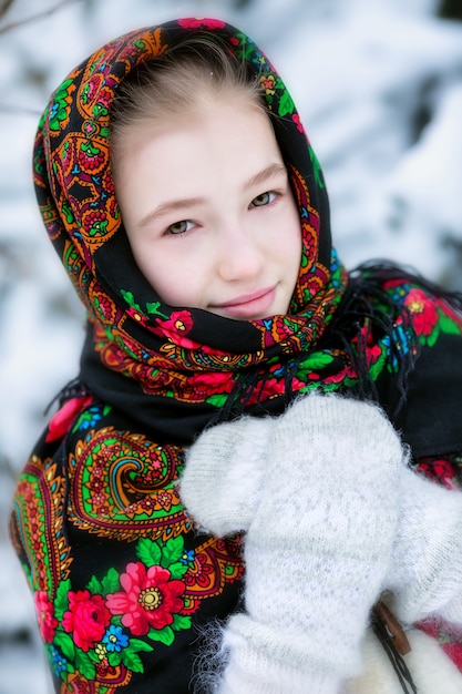 Une fille dans un foulard russe en hiver