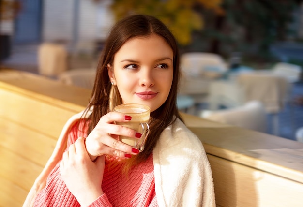 Fille dans le jardin du café buvant du café