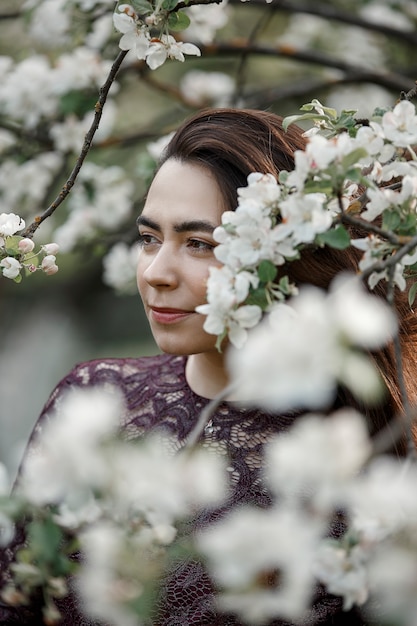 = Fille dans un jardin fleuri en robe marron