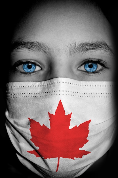 Fille dans un masque médical avec le drapeau du Canada sur elle