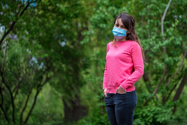 Fille dans un masque médical sur la nature. Fille se reposant dans le parc après la quarantaine COVID-19