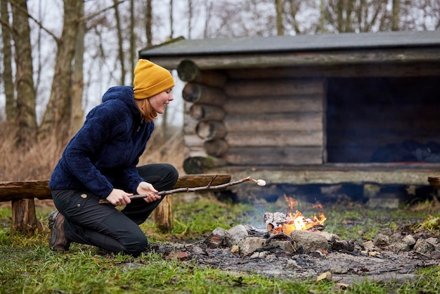 Fille dans la nature rôtissant de la guimauve