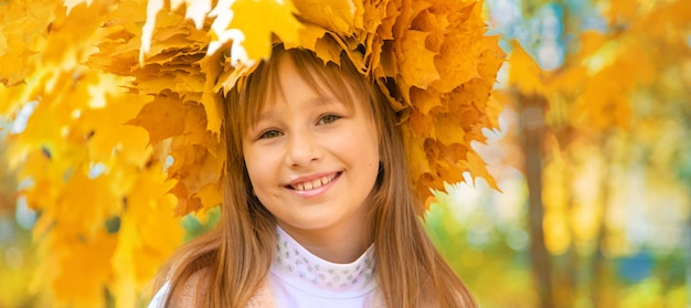 Fille dans le parc avec des feuilles d'automne.