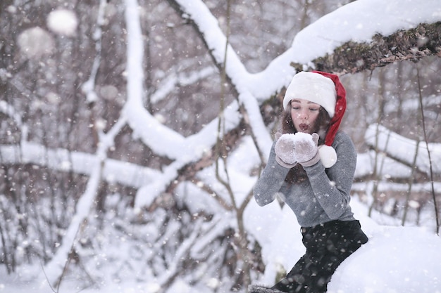 Fille dans un parc d'hiver l'après-midi dans les chutes de neige