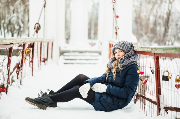 Fille dans un parc d'hiver couvert de neige