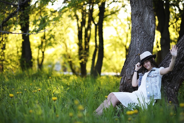 Fille dans le parc le soir d'une journée ensoleillée au printemps