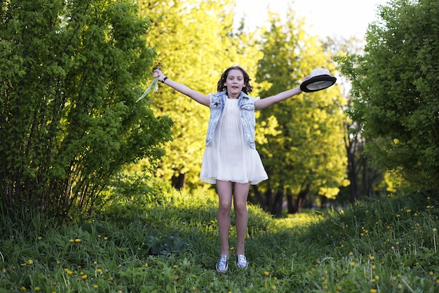 Fille dans le parc le soir d'une journée ensoleillée au printemps